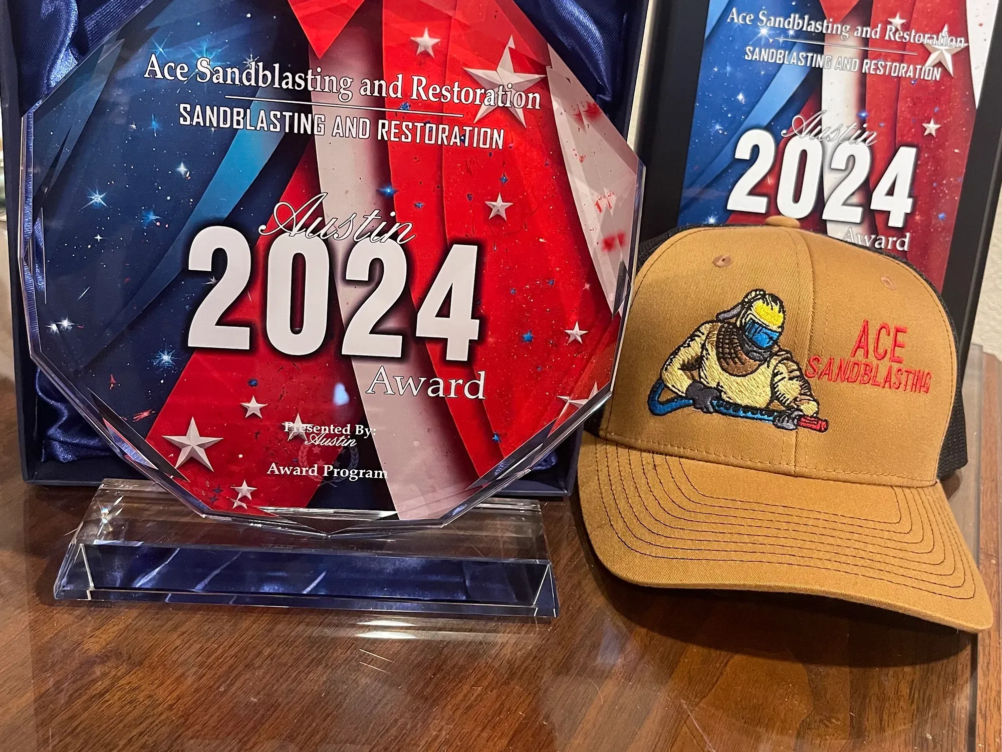 Ace Sandblasting 2024 business awards beside a branded cap