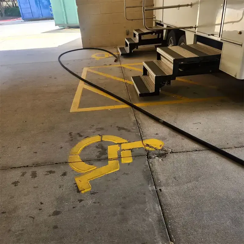 Yellow accessible-parking paint being blasted off a garage floor