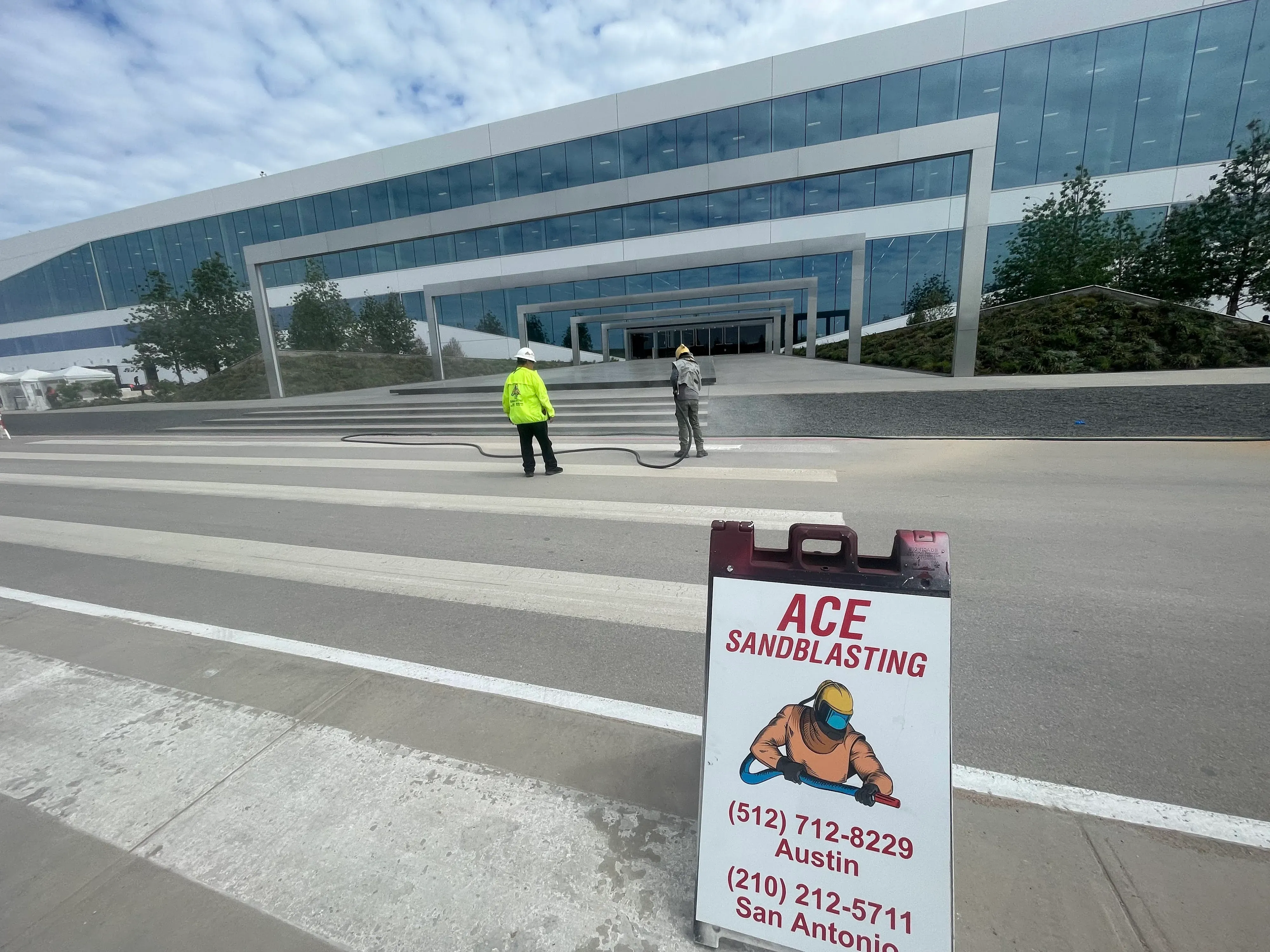 Ace Sandblasting job sign posted while crews work at a corporate campus