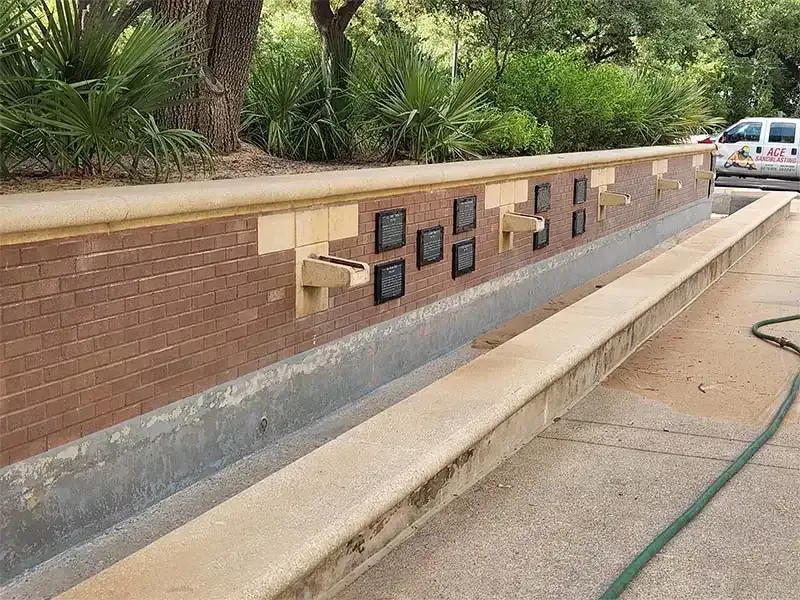 Brick planter wall with memorial plaques after sandblasting