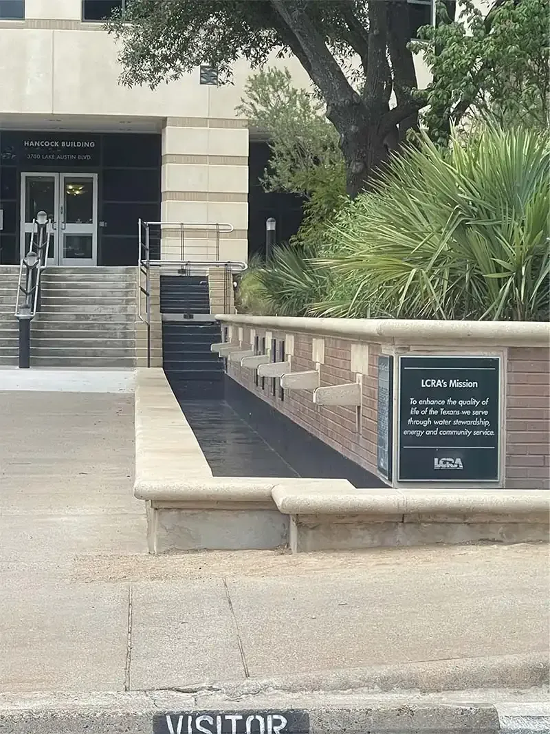 Building entrance with a coated planter wall and LCRA plaque