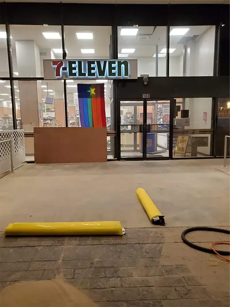 Blasted concrete apron outside a 7-Eleven storefront at night