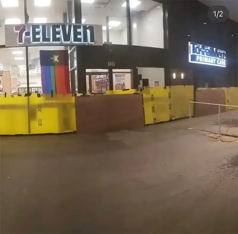 7-Eleven storefront with yellow barriers during overnight concrete prep