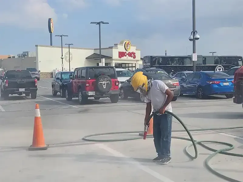 Blaster removing pavement markings in a busy Buc-ee’s parking lot