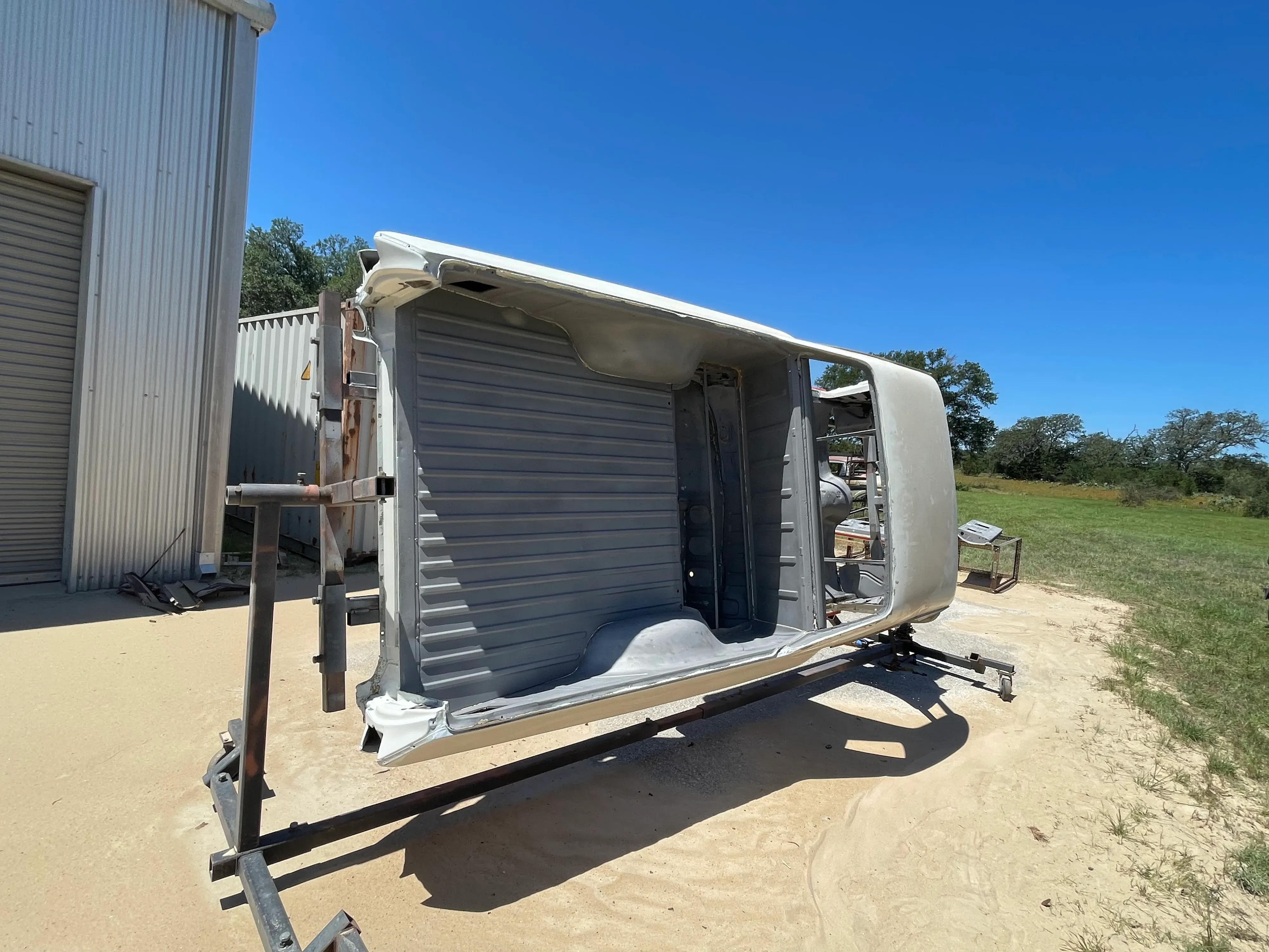 Classic car body on a rotisserie after paint-stripping sandblast