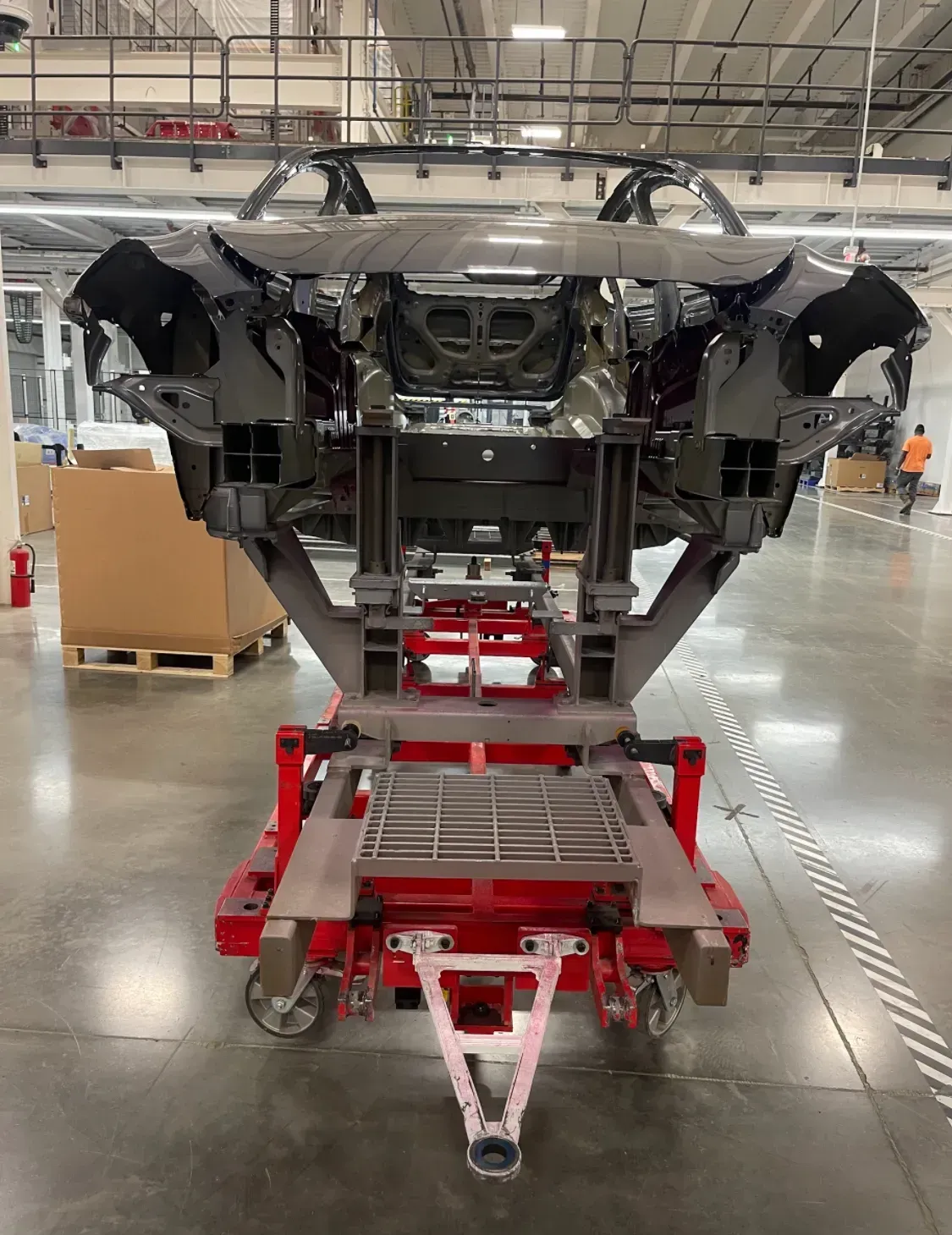 Red assembly cart with steel fixtures on a factory floor