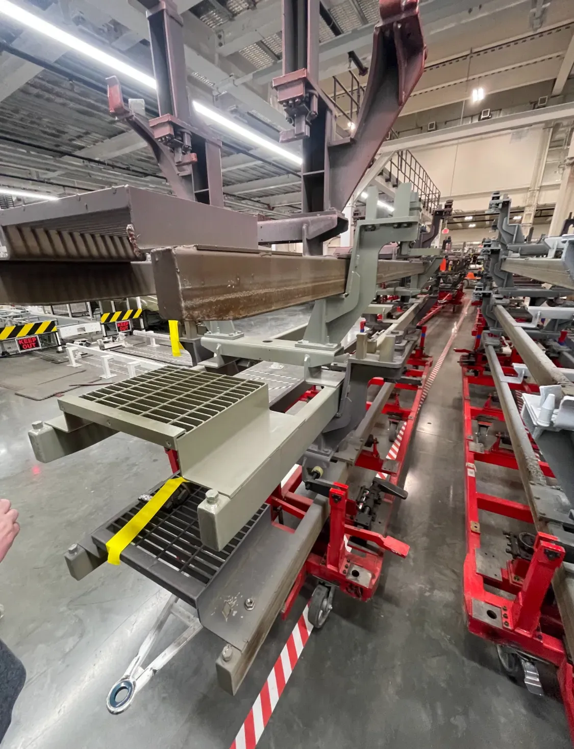 Industrial steel fixtures inside a manufacturing plant awaiting blasting