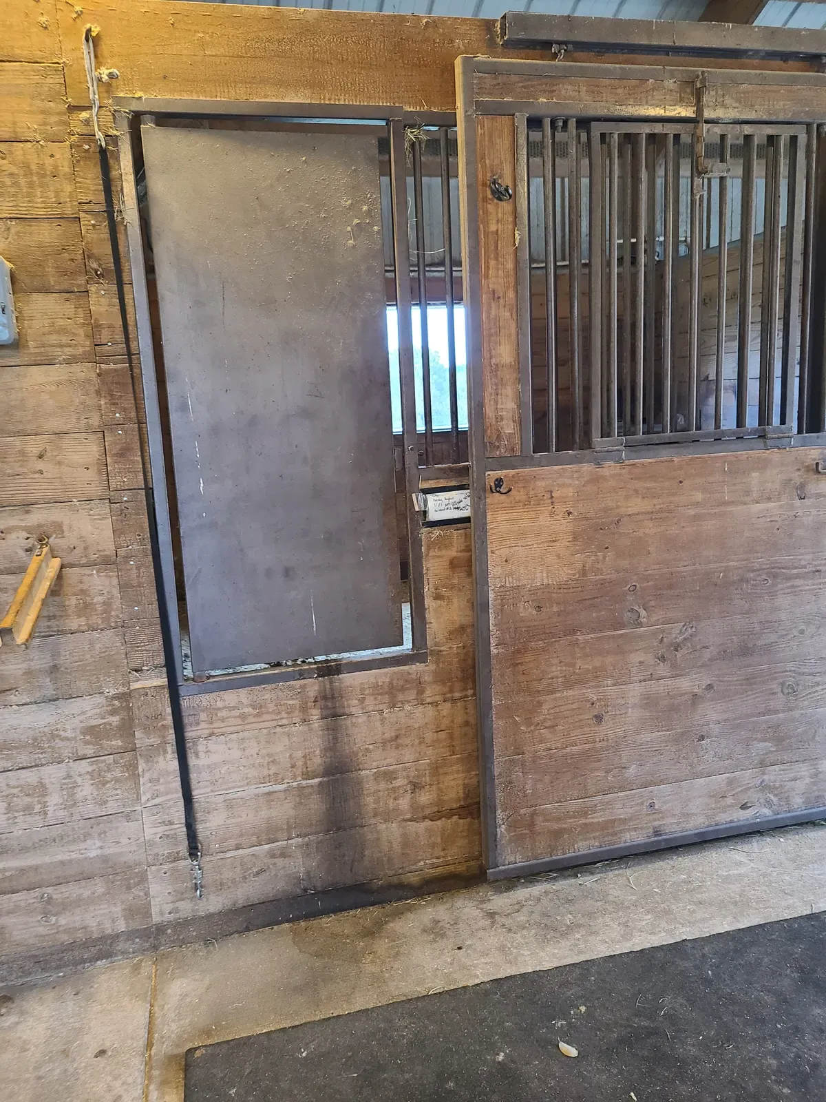 Horse stall with a steel door and wood walls after blasting