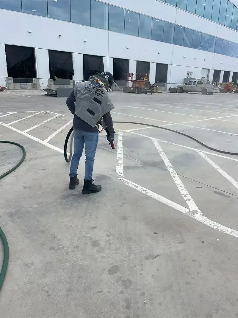 Technician removing parking striping at a warehouse loading dock