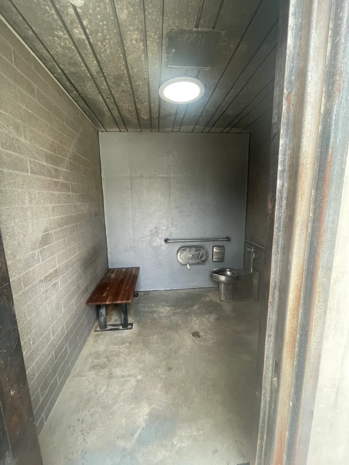 Concrete restroom stall interior prepared by sandblasting