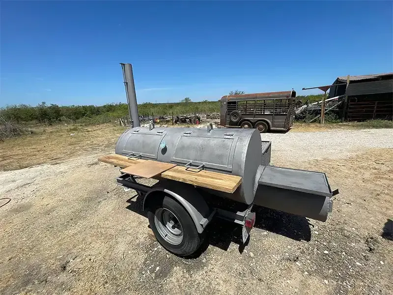 Steel barbecue smoker trailer at a ranch after sandblasting