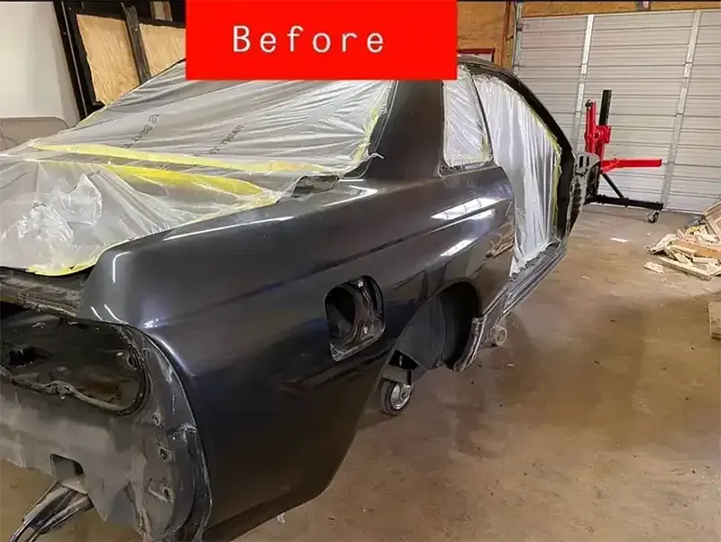 Before close-up of a sports car quarter panel in a shop