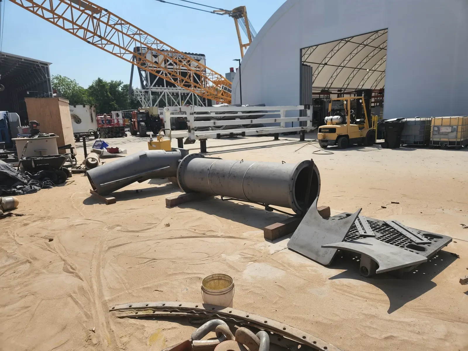 Large steel pipe sections in a fabrication yard prepped for blasting