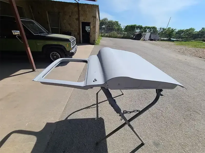 Pickup truck hood and door stripped to bare metal by sandblasting