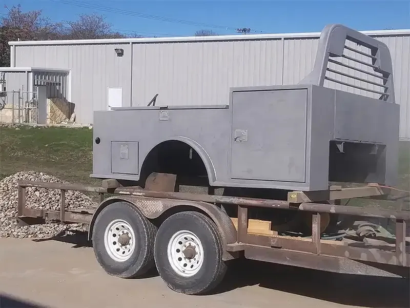Sandblasted steel truck service body loaded on a utility trailer