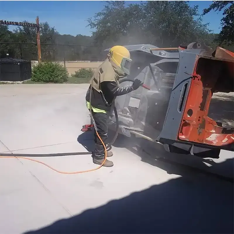 Blaster in full hood stripping paint from a vehicle body