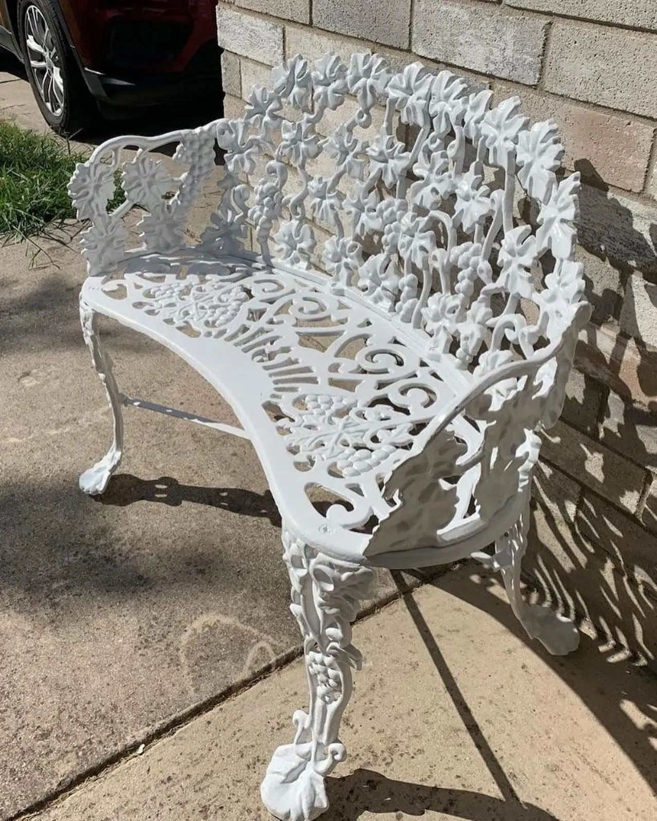 Ornate cast iron garden bench refinished white after sandblasting