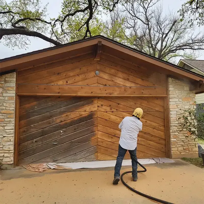 Blaster refinishing the chevron cedar wall of a home garage
