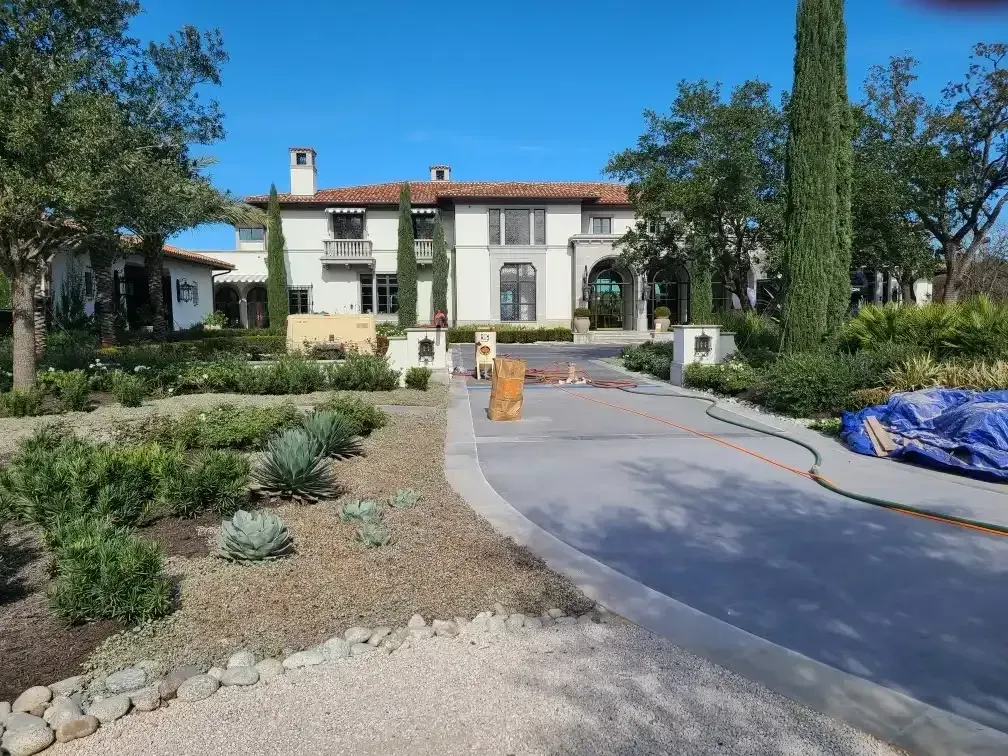 Curving concrete driveway at a Mediterranean-style estate after blasting