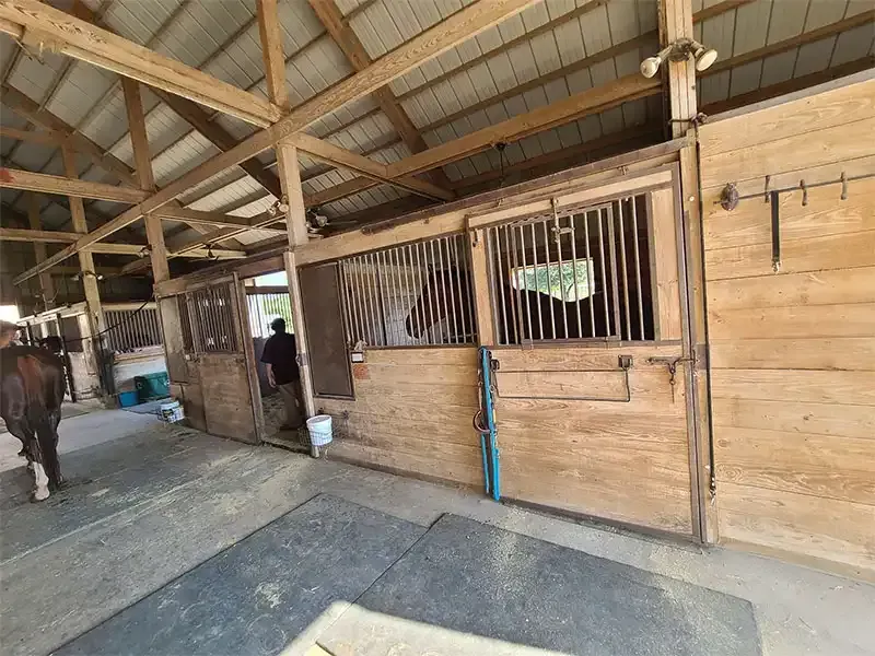 Weathered wooden horse barn stalls before sandblasting