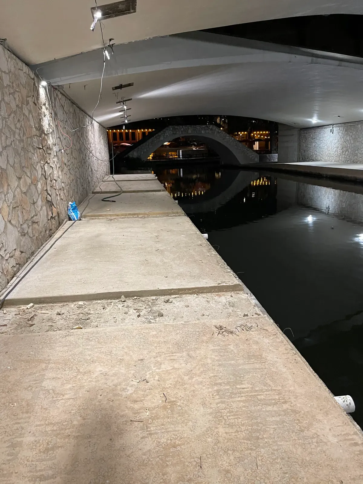 Indoor pool deck and stone wall during concrete surface prep