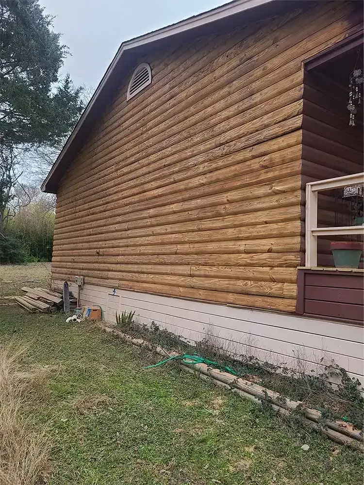 Log cabin siding restored to natural wood after sandblasting