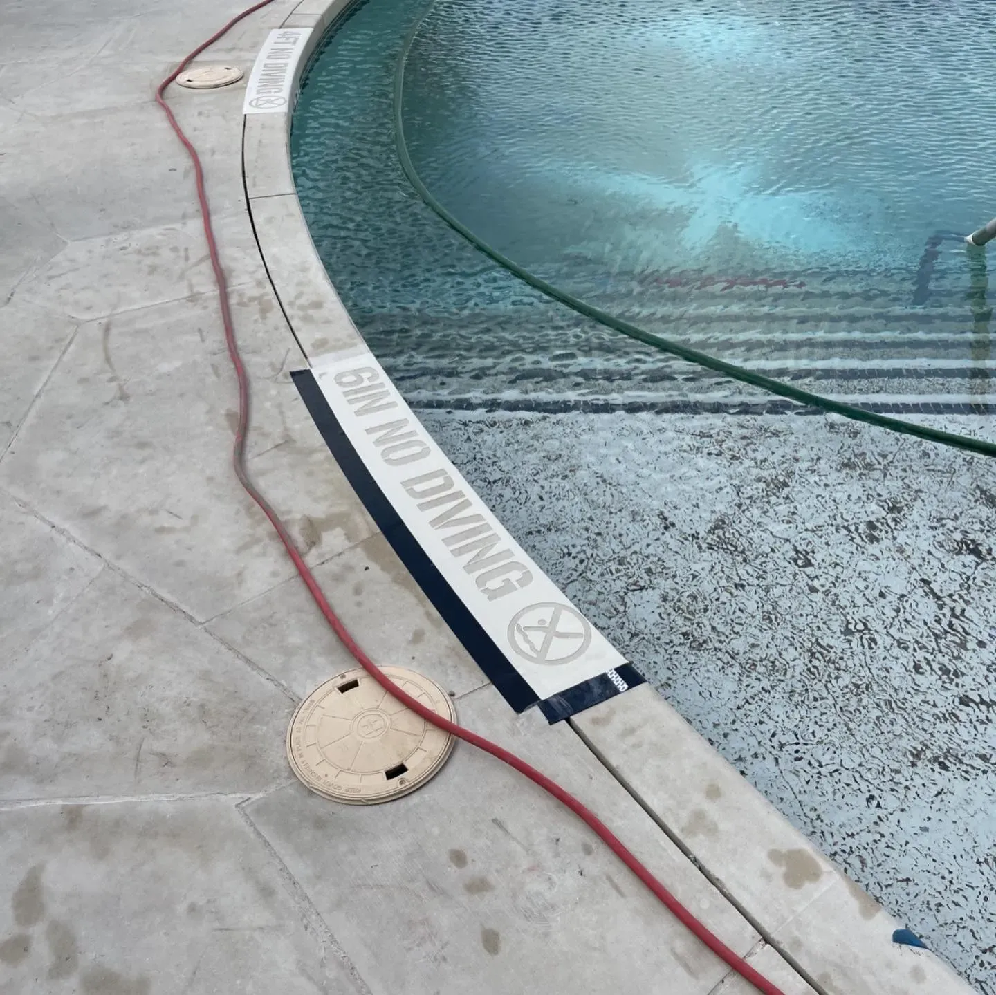 Pool deck coping and depth marker after concrete sandblasting