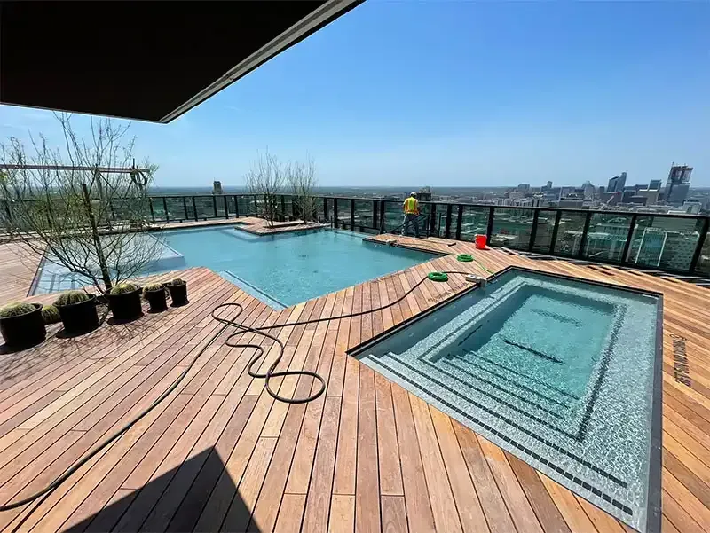 Rooftop pool and hardwood deck with a downtown skyline view