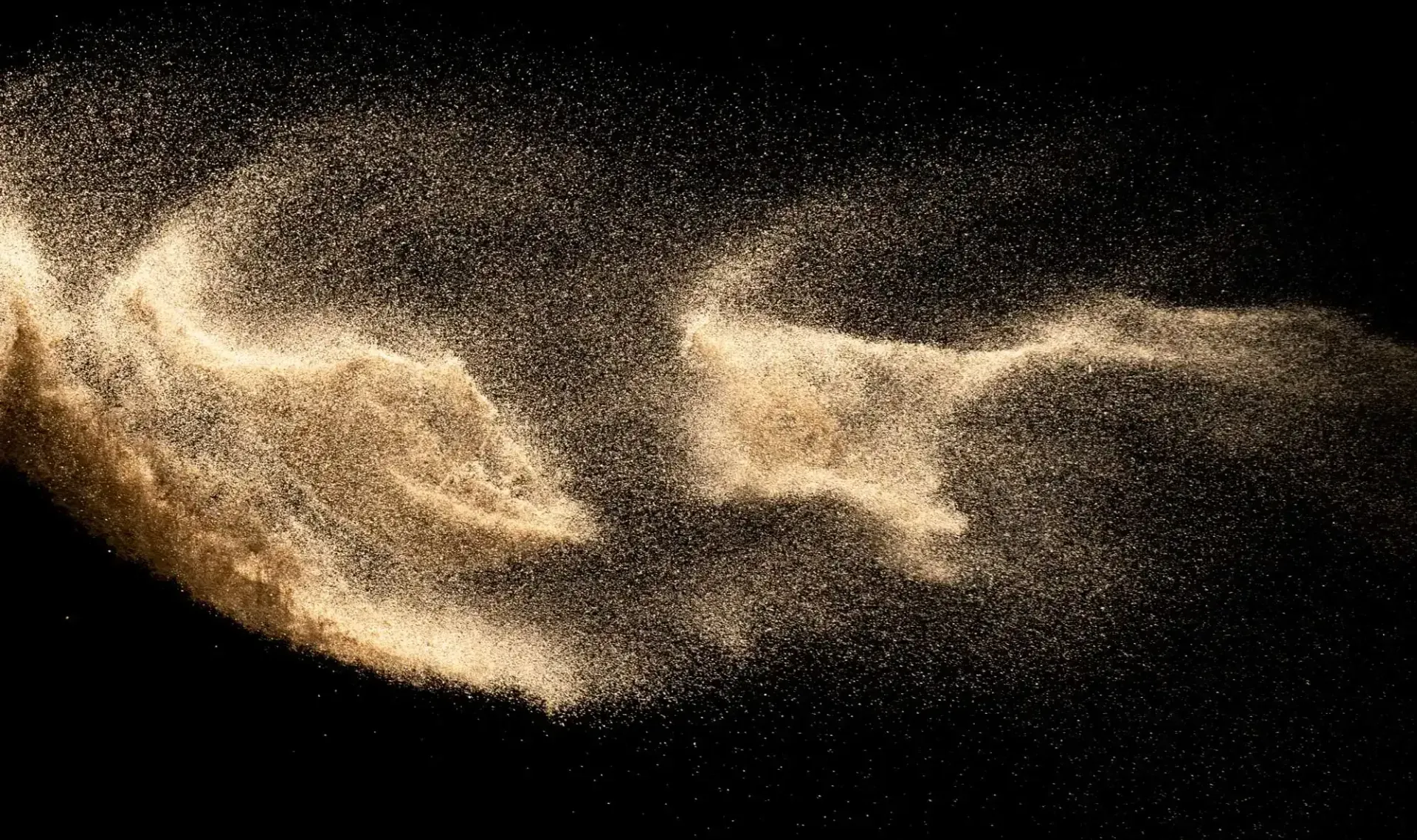 Burst of blasting sand against a black background